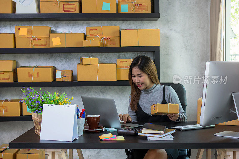 年轻的亚洲青少年业主商业女性在家工作，网上购物，检查订单和准备包装的产品与办公设备，企业家和阿尔法一代的生活方式的概念