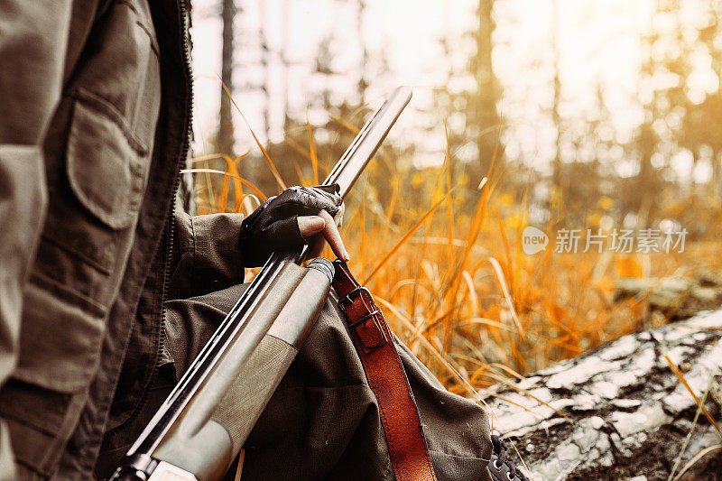 拿着枪的女猎人。在树林里打猎。