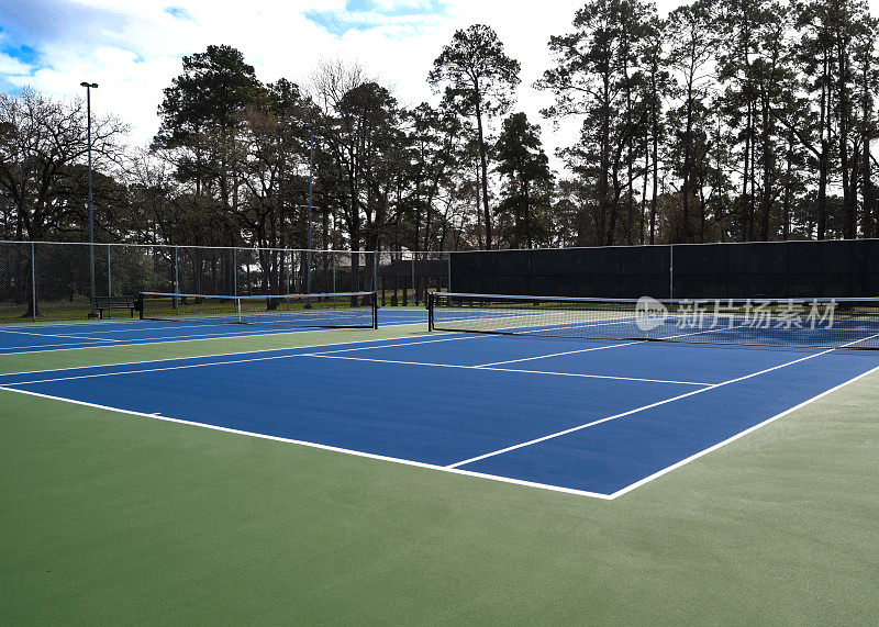 亮蓝色和绿色的网球场，适合健身。