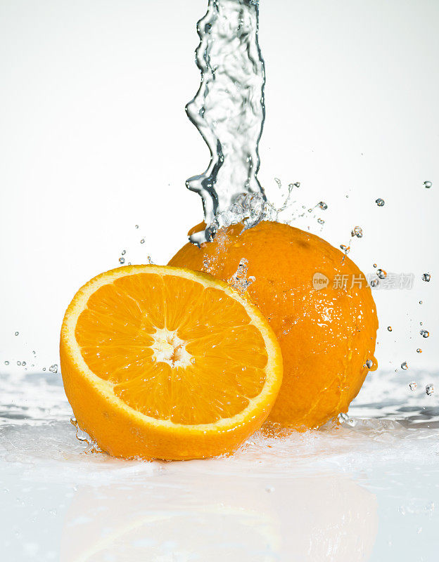 新鲜的橙子。水飞溅。特写镜头。