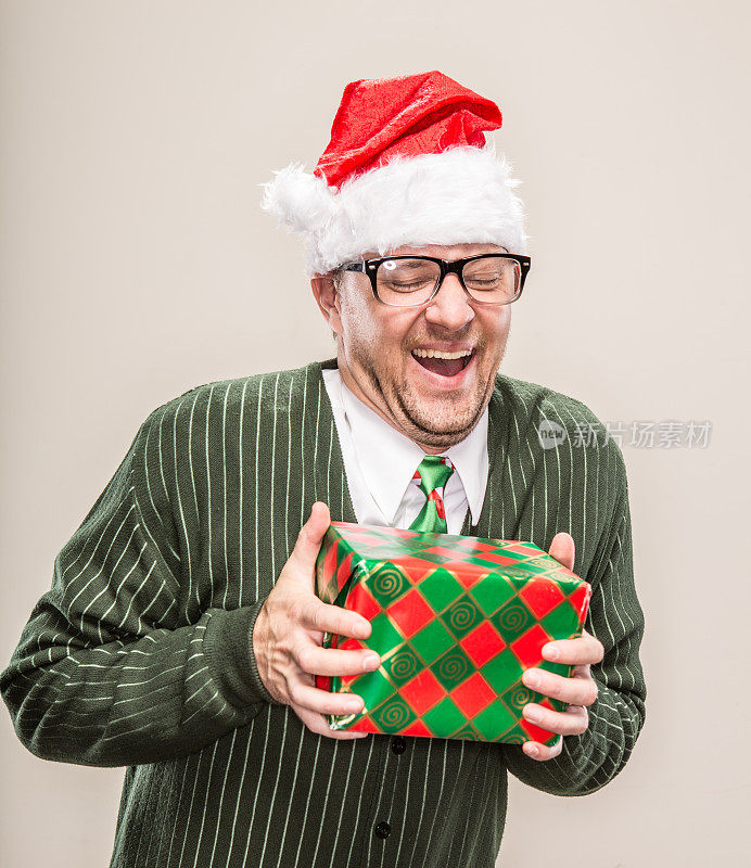 傻笑的圣诞老人拿着包装好的节日礼物