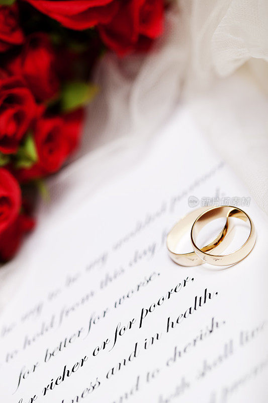 结婚戒指，婚誓和红玫瑰花束