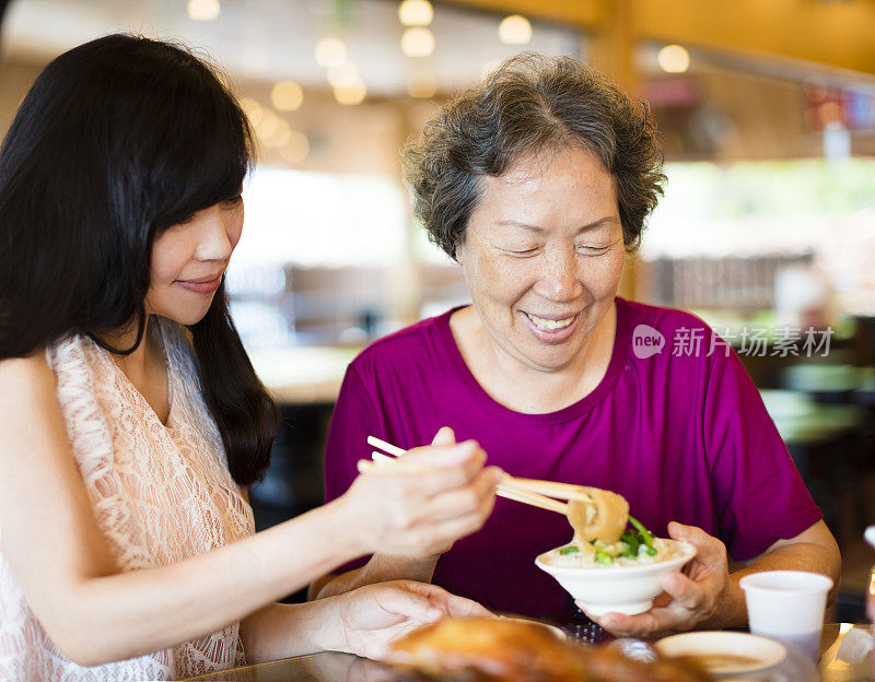快乐的女儿和年长的母亲喜欢在餐厅吃饭