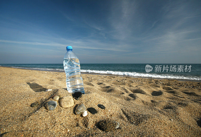 沙滩上一瓶清凉的水