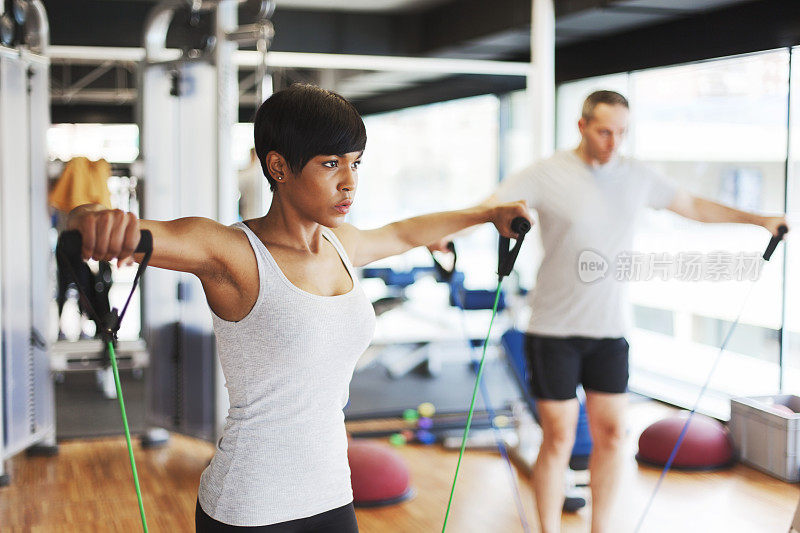 在健身房用阻力带锻炼。