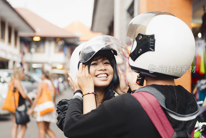 在巴厘岛乌布，一名印度尼西亚妇女戴着头盔微笑约会