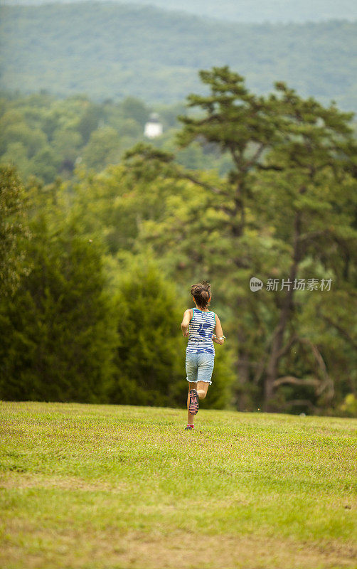 小女孩夏天在公园里跑步。