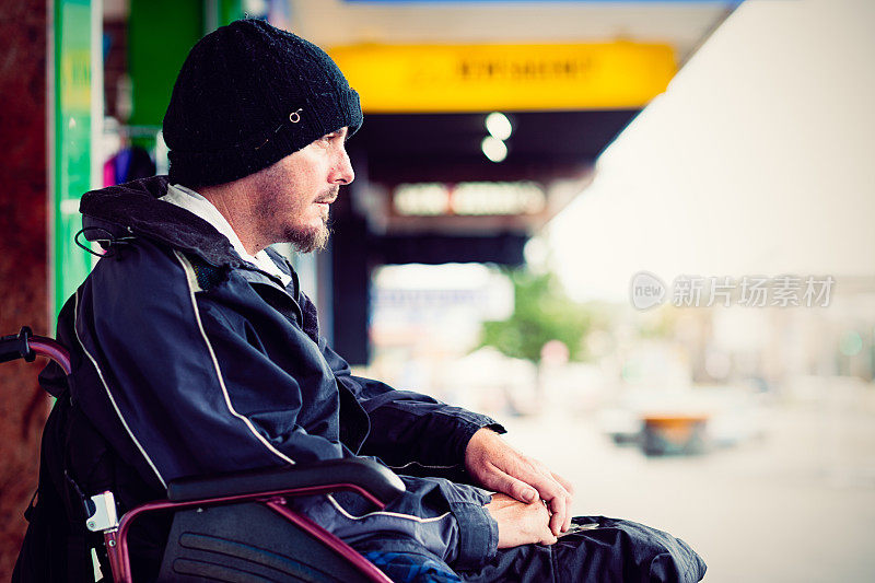 无家可归的年轻残疾人坐在轮椅上