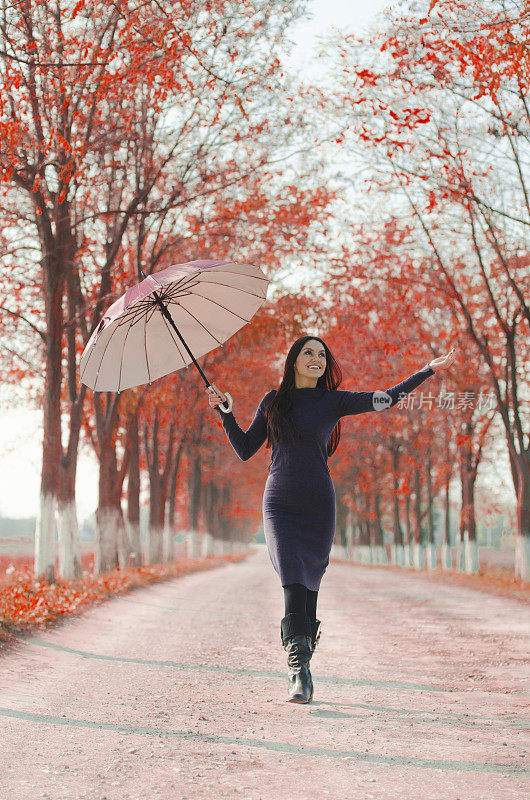 美丽的女孩拿着伞检查是否下雨