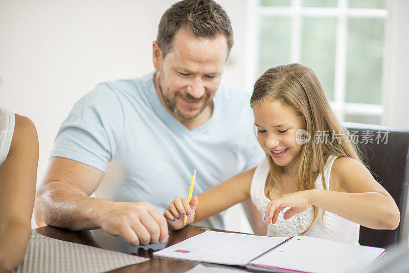 父亲帮助女儿完成家庭教育作业