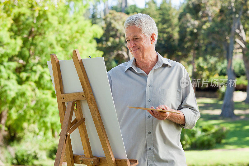 一个人在户外画画时面带微笑