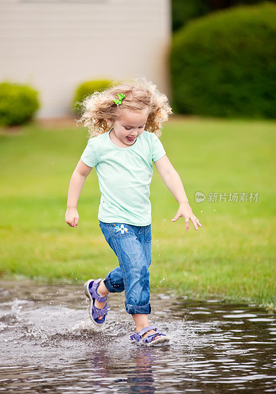 小女孩在水坑里跑