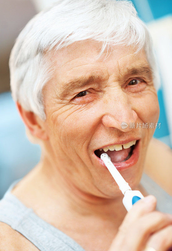一个快乐的老人刷牙的特写