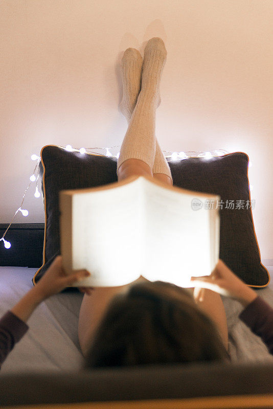 女人在床上放松看书的照片
