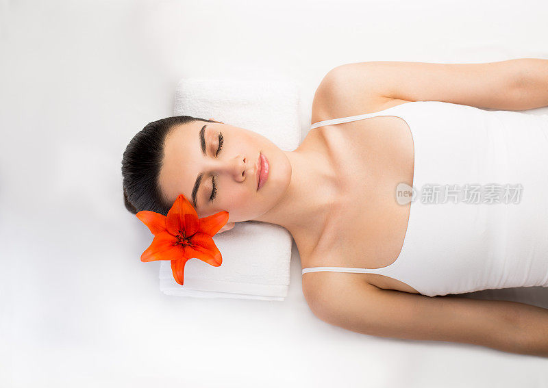 迷人的拉丁女人躺下耳朵上放着花