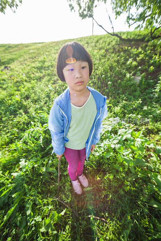 一个中国女孩在草地上踢足球