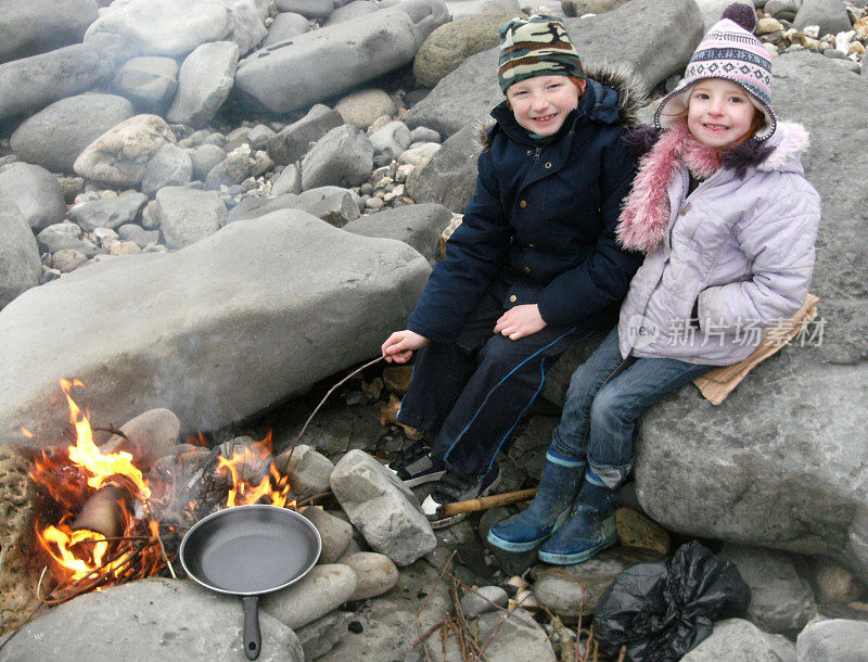 莱姆里吉斯海滩上，孩子们在篝火上做饭