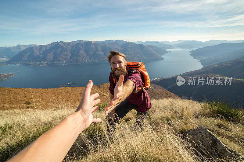 徒步旅行者在山路上帮助同伴