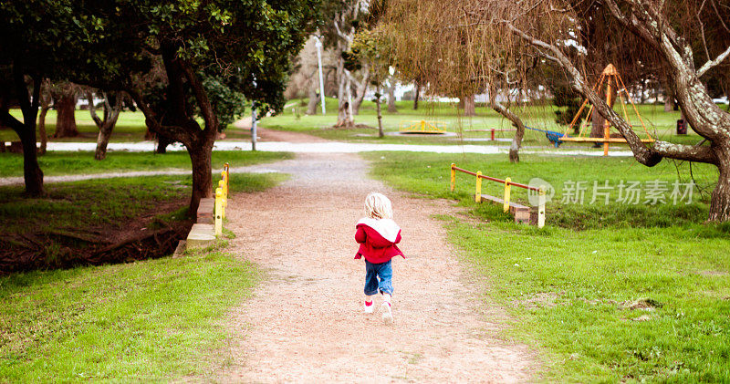 小女孩在公园的小路上奔跑，后视镜看到了