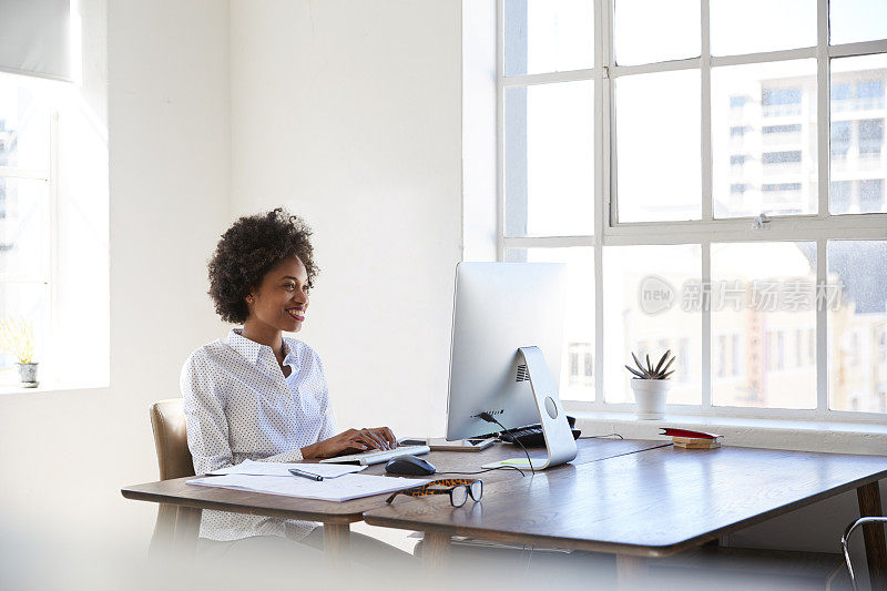 年轻的黑人妇女在办公室用电脑工作