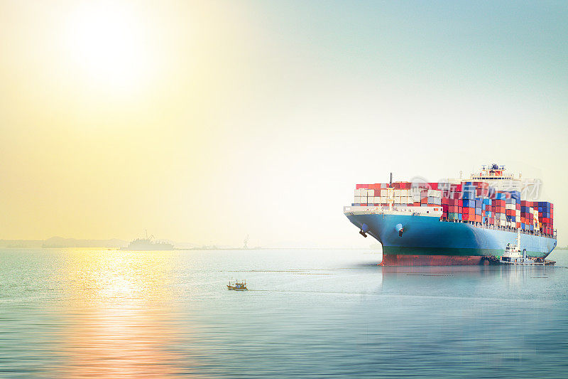 国际集装箱货船在海上的日落天空，货物运输，航海船舶