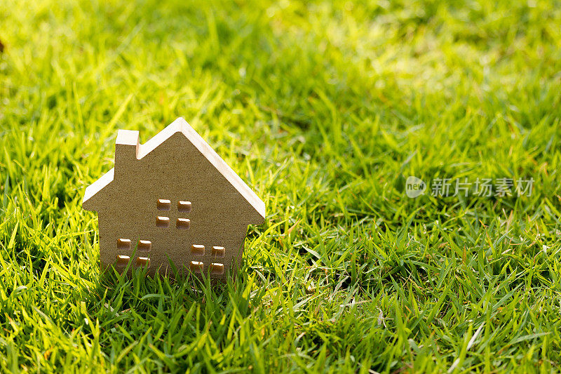绿色草地上的小房子模型与阳光搏斗。