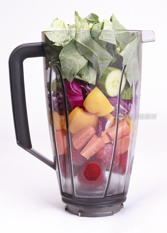把新鲜的水果和蔬菜混合在一个果汁杯里。——孤立