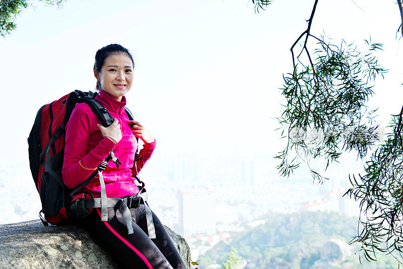 女背包客在山顶岩石休息