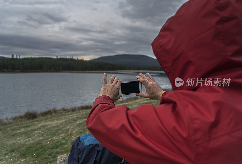 在湖中用手机拍照