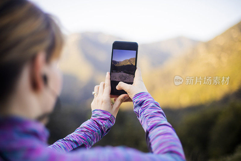 一个女人在登山时拍照