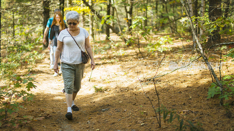 年老的银发女人，祖母，和她的孙女，少女在森林里徒步旅行