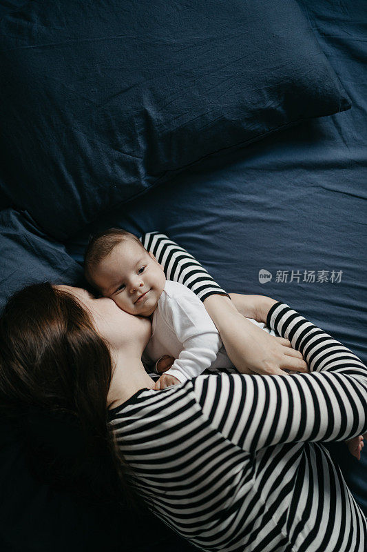 年轻的母亲和她刚出生的男婴躺在床上