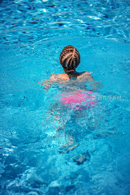 女孩在游泳池里游泳