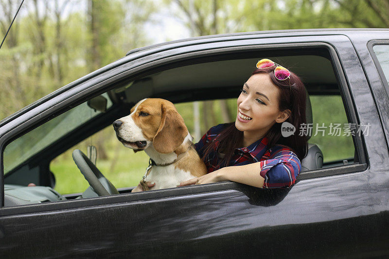 一个年轻女人和她的狗在车里