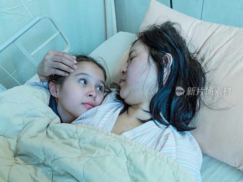 母亲和女儿一起躺在医院的病床上