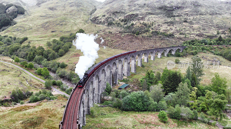 蒸汽火车穿过格伦芬南高架桥，无人机鸟瞰图-苏格兰，英国