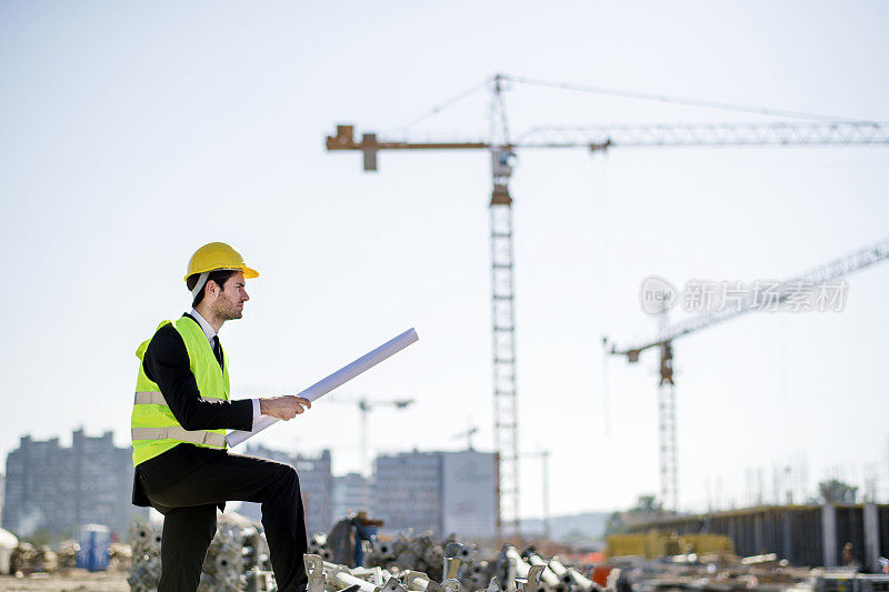 专业工程师建筑工人戴安全帽和图纸施工现场