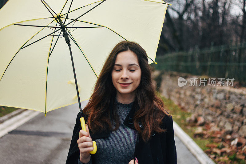 美丽的年轻女子享受着雨天