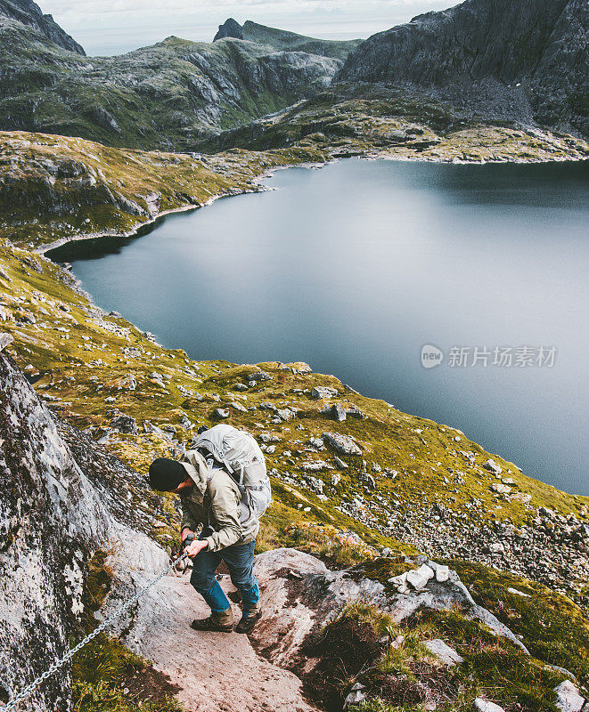 攀登者在山中攀登的人持有链条旅行的生活方式冒险概念徒步旅行旅行的欲望夏季假期户外湖为背景