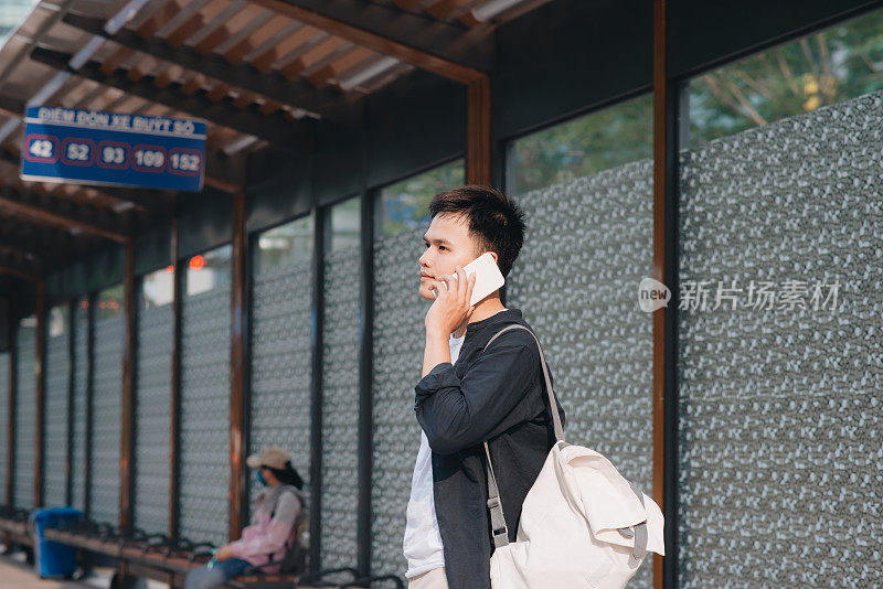 胡志明市，一名男子在等电车时用智能手机打电话