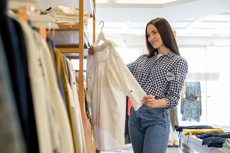 在精品店里挑选衣服的漂亮女人