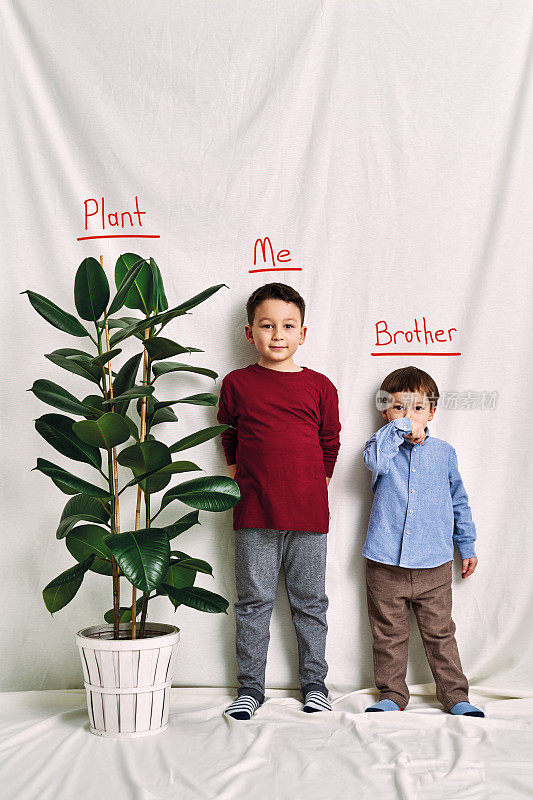 可爱的孩子在测量他的身高。成长与竞争的概念。