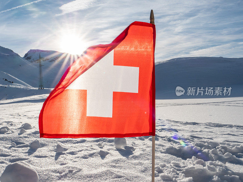 瑞士国旗矗立在瑞士阿尔卑斯山的雪山上，格劳宾登州