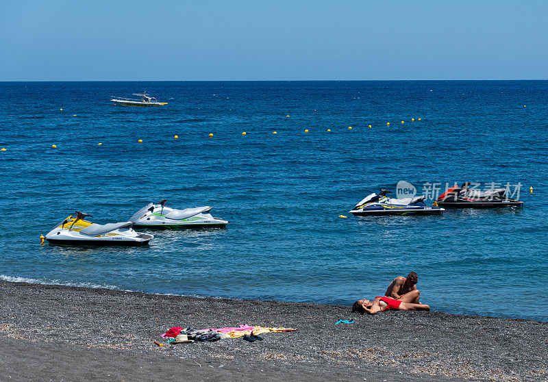 爱琴海佩里萨海滩附近停泊着四辆水上摩托，等待着游客