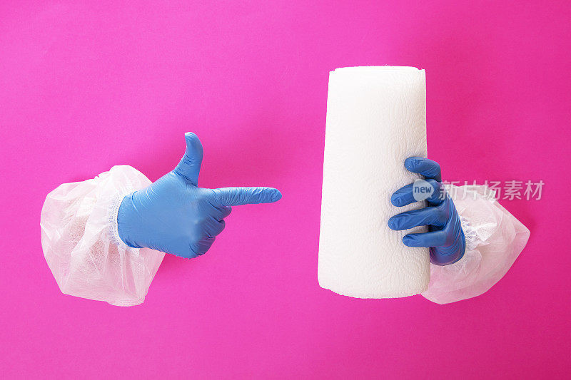 双手戴着蓝色医疗手套，上面有几卷纸巾