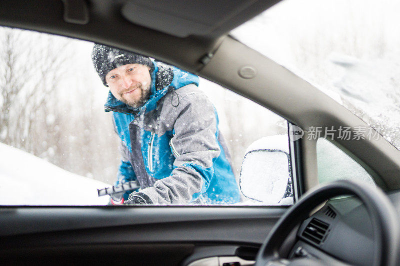 刮着车窗外的冰雪，男人正看着车窗外