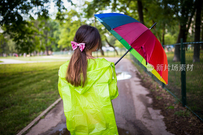 漂亮凉爽的女人带着五颜六色的雨伞在秋天的一天