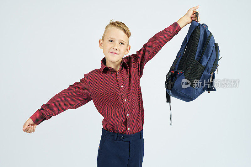 一个男生把书包举过头顶。
