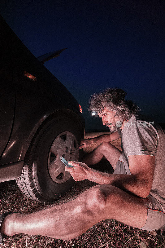 汽车修理。幸运的我。黄昏时分在荒无人烟的地方给汽车换轮胎。DIY