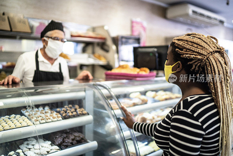 一名年轻女子在面包店用面膜订购食品